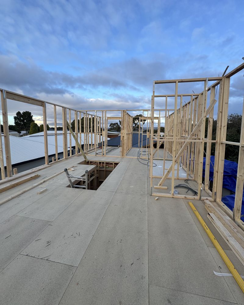 A new upper floor sheeted over the house, with timber wall frames rising around it